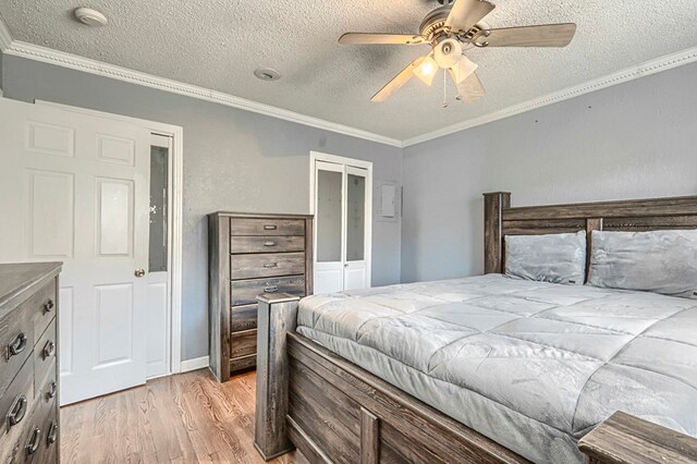710 W Nobles Ave, Midland, TX 79701 - bedroom with a textured ceiling, light wood-style floors, ornamental molding, a closet, and a ceiling fan