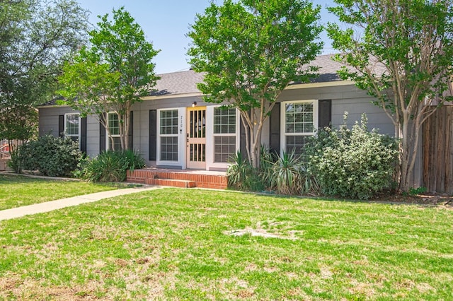 710 W Nobles Ave, Midland, TX 79701 - view of property hidden behind natural elements featuring a front yard and a shingled roof