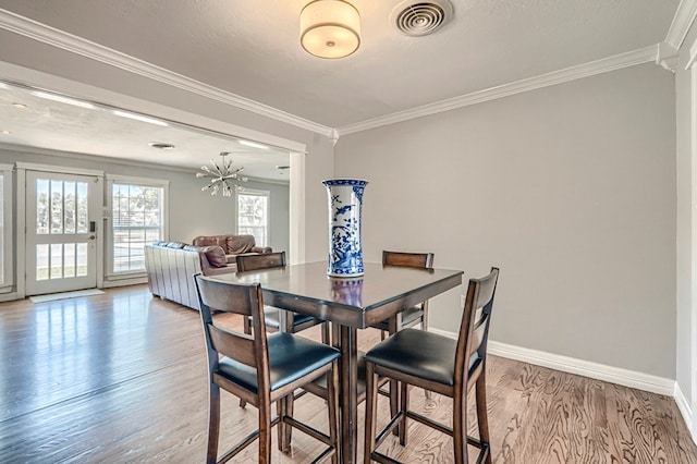 710 W Nobles Ave, Midland, TX 79701 - dining area featuring crown molding, light wood-style flooring, baseboards, and a chandelier
