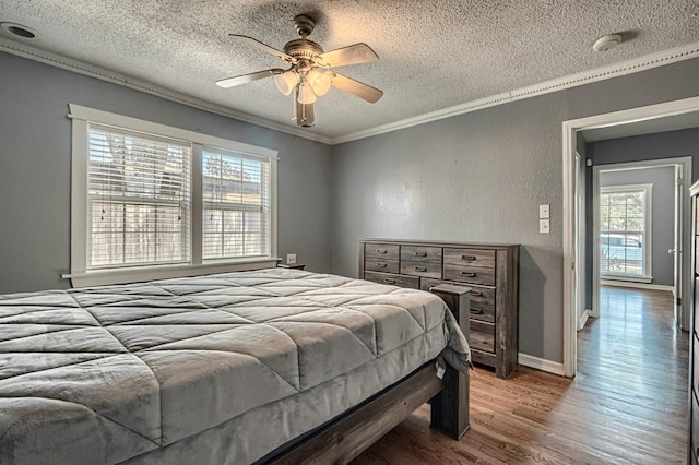 710 W Nobles Ave, Midland, TX 79701 - bedroom featuring a textured ceiling, multiple windows, wood finished floors, ornamental molding, and ceiling fan
