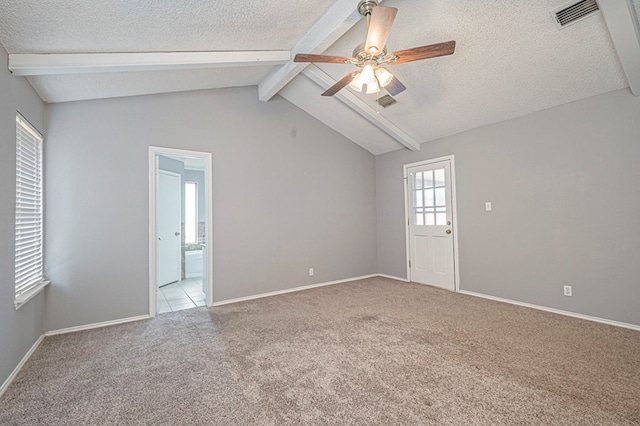 spare room with light carpet, visible vents, a ceiling fan, lofted ceiling with beams, and a textured ceiling