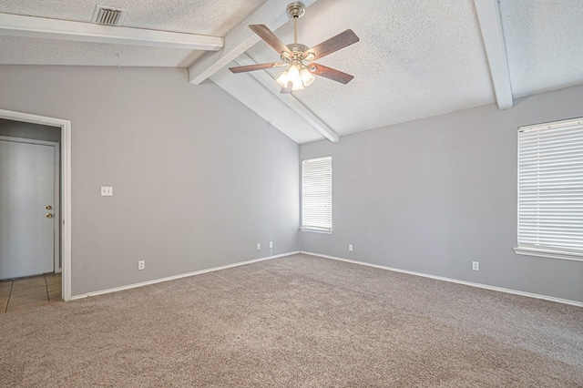 carpeted spare room featuring a textured ceiling, ceiling fan, lofted ceiling with beams, and visible vents