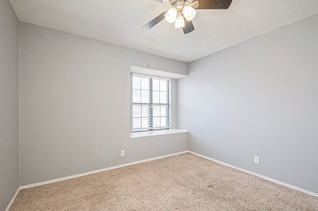 carpeted empty room featuring a ceiling fan, baseboards, a textured ceiling, and a textured wall