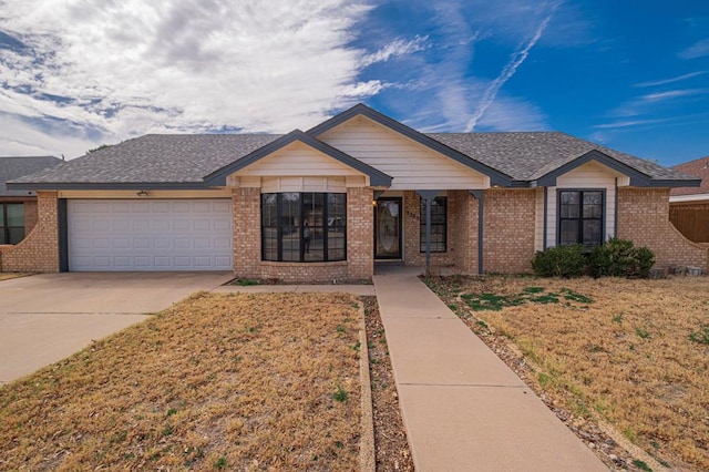 ranch-style home featuring a garage, driveway, brick siding, and a front lawn