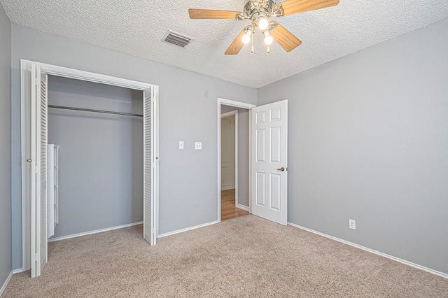 unfurnished bedroom featuring a textured ceiling, a ceiling fan, baseboards, a closet, and carpet