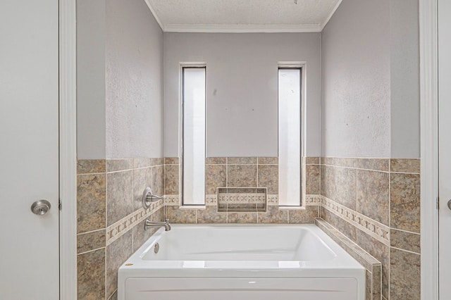 bathroom featuring tile walls, a garden tub, crown molding, and a textured ceiling