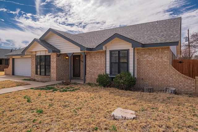 ranch-style house featuring brick siding, roof with shingles, concrete driveway, an attached garage, and fence