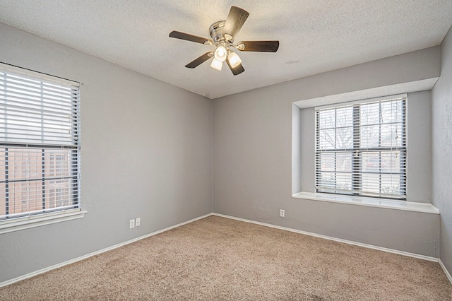 spare room featuring carpet flooring, ceiling fan, a textured ceiling, and baseboards