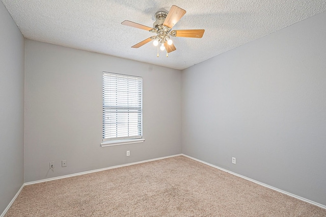 spare room featuring carpet, ceiling fan, baseboards, and a textured ceiling