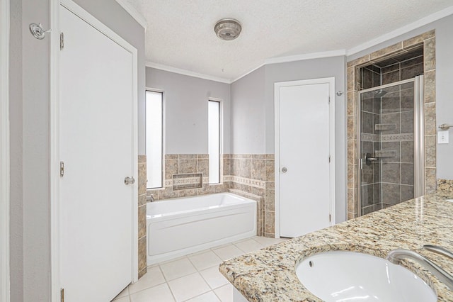 full bathroom featuring a textured ceiling, a sink, a bath, tile patterned floors, and a stall shower