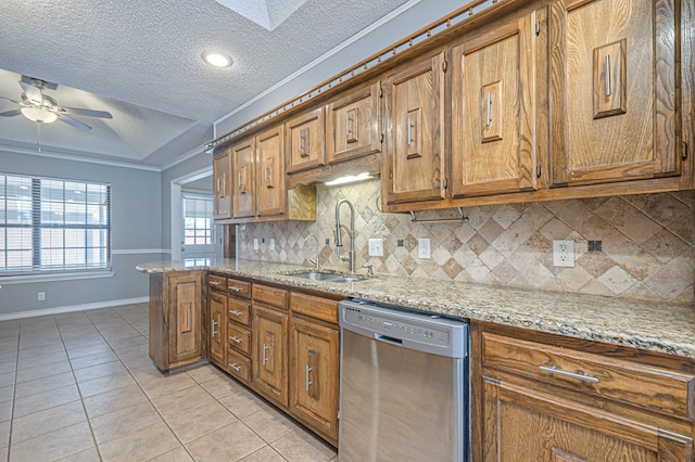 kitchen with light tile patterned floors, stainless steel dishwasher, a sink, and brown cabinets