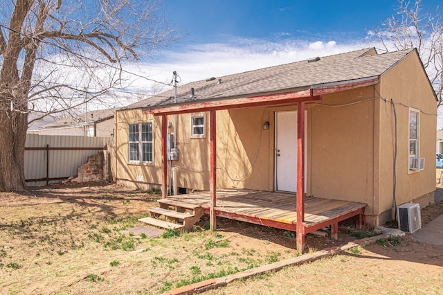 back of house with fence and roof with shingles