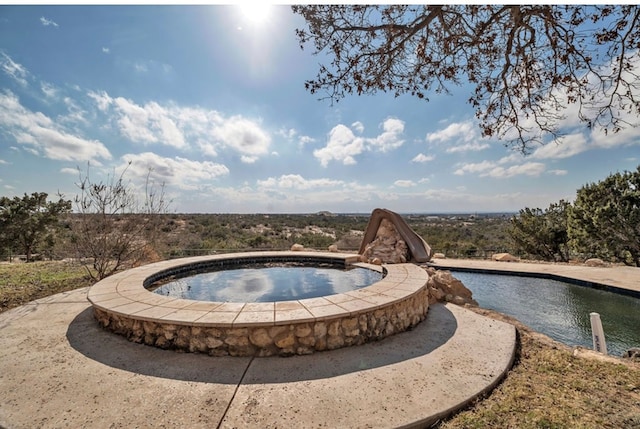 view of pool featuring an in ground hot tub and a water slide