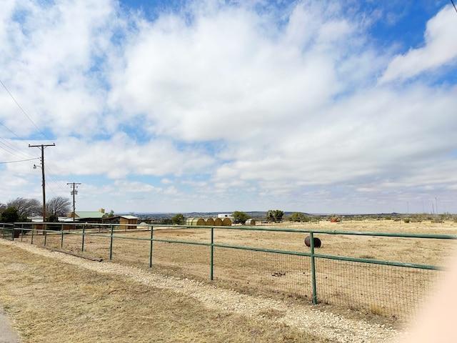 view of yard with a rural view and fence