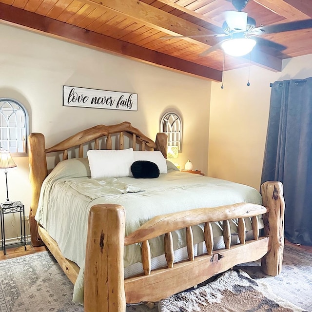 bedroom featuring beamed ceiling, wood ceiling, and a ceiling fan