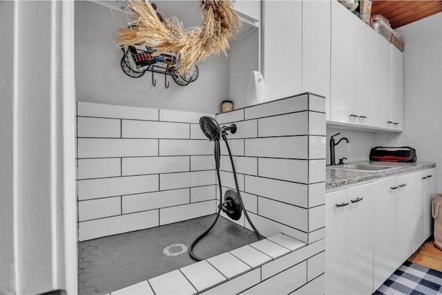 interior space featuring a tile shower and a sink