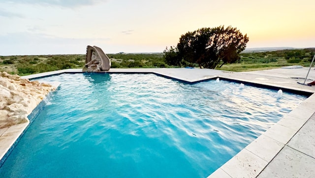 view of pool at dusk