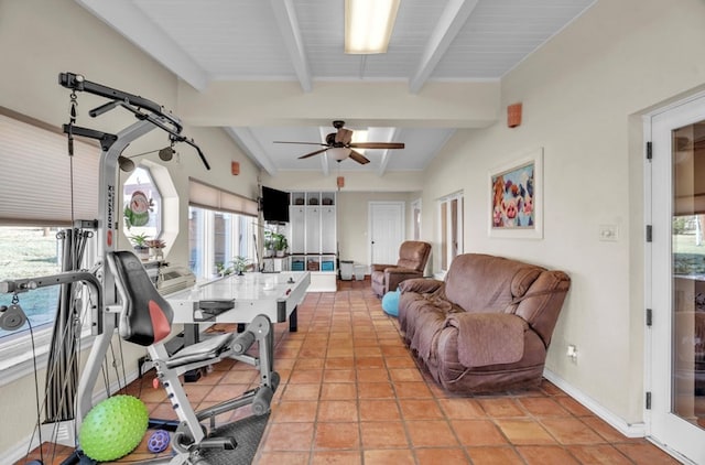 exercise room with lofted ceiling, light tile patterned floors, a ceiling fan, and baseboards