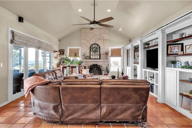 living area with ceiling fan, plenty of natural light, light tile patterned floors, and a large fireplace