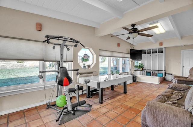 exercise room featuring lofted ceiling, light tile patterned flooring, a ceiling fan, and baseboards