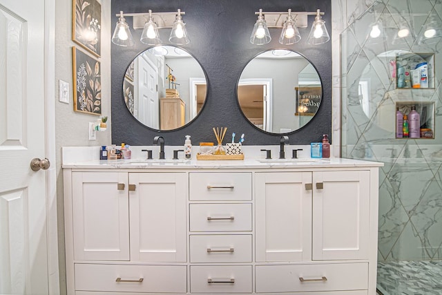 full bathroom with a textured wall, a marble finish shower, and a sink