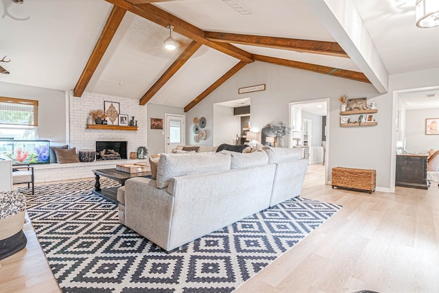 living room featuring a fireplace, light wood-style flooring, beamed ceiling, and baseboards
