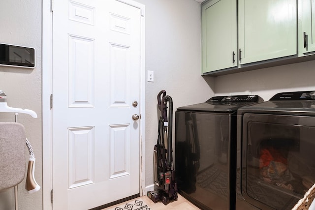 clothes washing area featuring washer and dryer and cabinet space