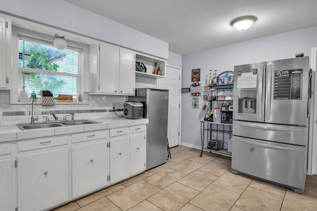 2004 N Monticello St, Big Spring, TX 79720 - kitchen with stainless steel fridge, white cabinetry, decorative backsplash, freestanding refrigerator, and open shelves