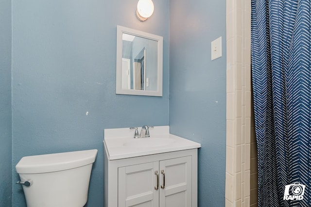 bathroom with a shower, vanity, and toilet