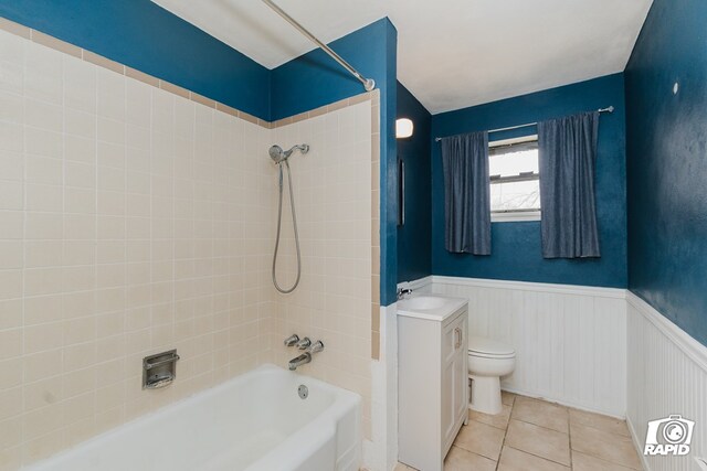 full bathroom with tile patterned floors, vanity, tiled shower / bath combo, and toilet