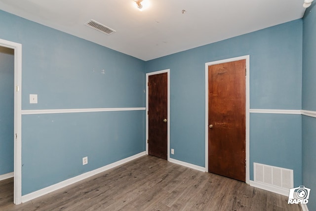 unfurnished bedroom featuring a closet and dark hardwood / wood-style flooring