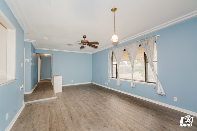 empty room featuring ceiling fan, dark hardwood / wood-style flooring, and crown molding