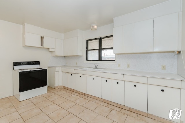 kitchen featuring tasteful backsplash, electric stove, sink, and white cabinets