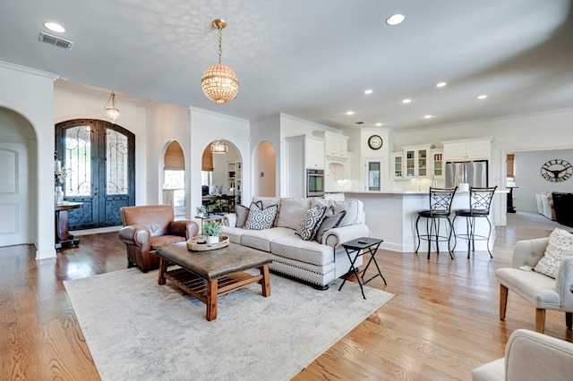801 Keystone Ct, Midland, TX 79705 - living room featuring arched walkways, ornamental molding, french doors, recessed lighting, and light wood-type flooring
