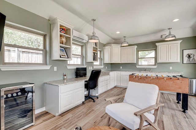801 Keystone Ct, Midland, TX 79705 - home office with beverage cooler, a wall mounted air conditioner, a sink, light wood-style flooring, and plenty of natural light