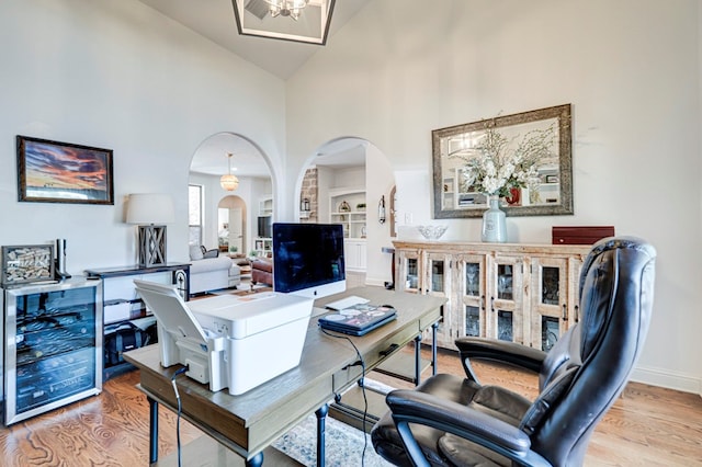 801 Keystone Ct, Midland, TX 79705 - office featuring wine cooler, arched walkways, wood finished floors, high vaulted ceiling, and baseboards