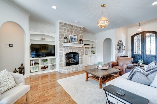 801 Keystone Ct, Midland, TX 79705 - living area featuring arched walkways, ornamental molding, french doors, built in shelves, and wood finished floors
