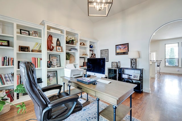 801 Keystone Ct, Midland, TX 79705 - office featuring wood finished floors, high vaulted ceiling, arched walkways, a chandelier, and baseboards