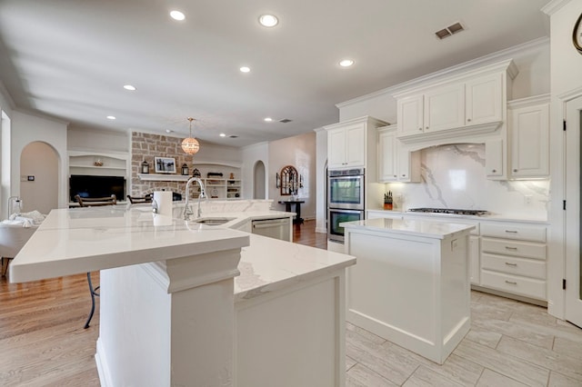 801 Keystone Ct, Midland, TX 79705 - kitchen featuring a spacious island, a sink, arched walkways, appliances with stainless steel finishes, and recessed lighting