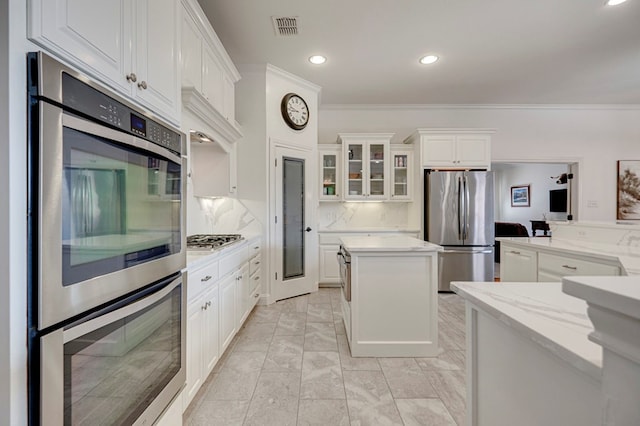 801 Keystone Ct, Midland, TX 79705 - kitchen featuring stainless steel appliances, ornamental molding, white cabinets, recessed lighting, and glass insert cabinets