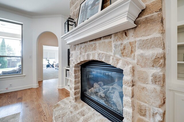 801 Keystone Ct, Midland, TX 79705 - detailed view of wood finished floors, a fireplace, crown molding, baseboards, and arched walkways