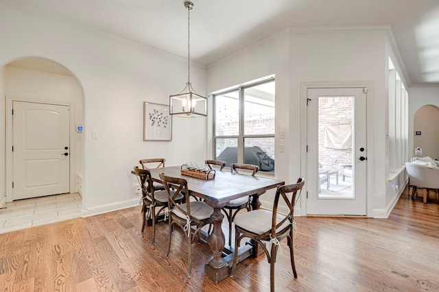 801 Keystone Ct, Midland, TX 79705 - dining room featuring arched walkways, light wood finished floors, ornamental molding, baseboards, and a chandelier