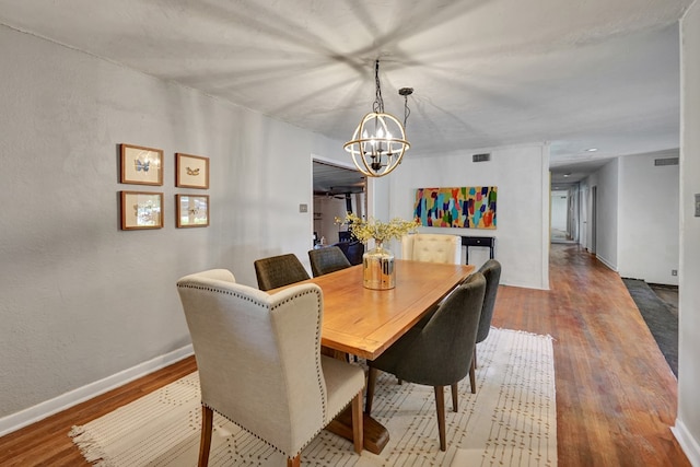 2202 Princeton Ave, Midland, TX 79701 - dining area with a chandelier, wood finished floors, and baseboards
