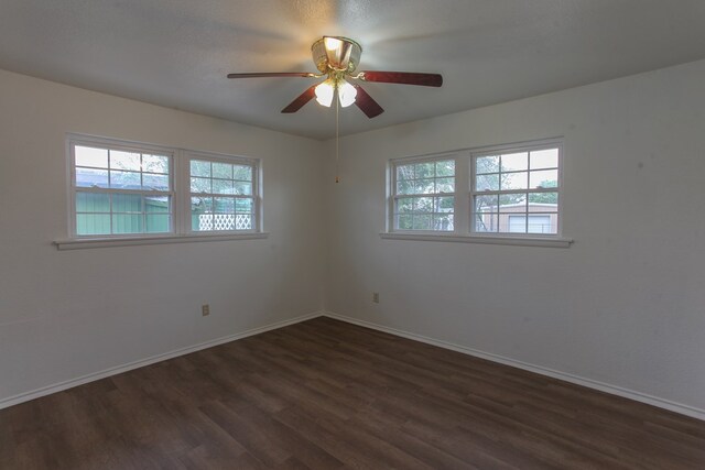 empty room with ceiling fan and dark hardwood / wood-style floors