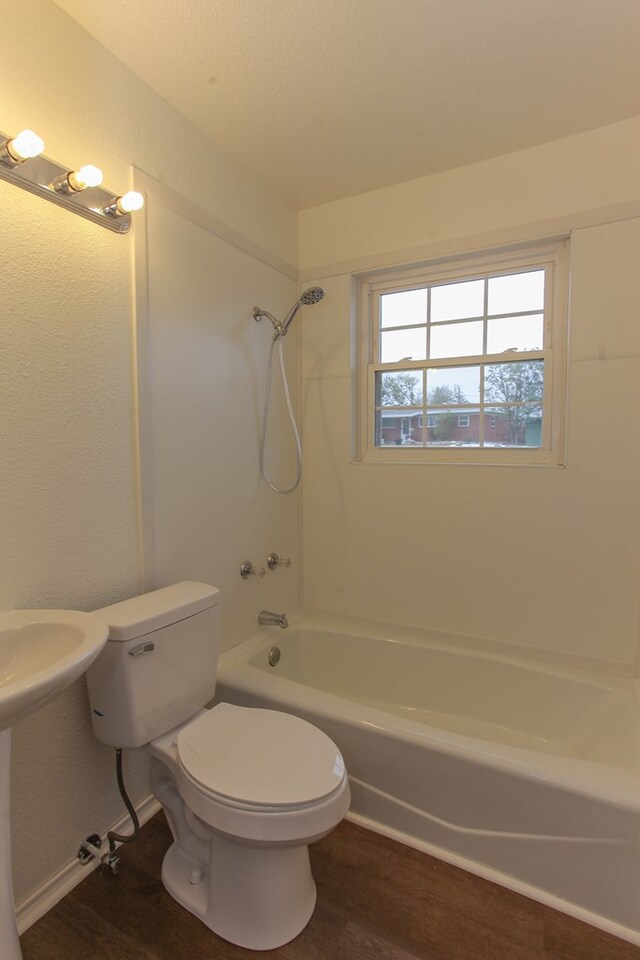 full bathroom featuring sink, toilet, washtub / shower combination, and hardwood / wood-style flooring