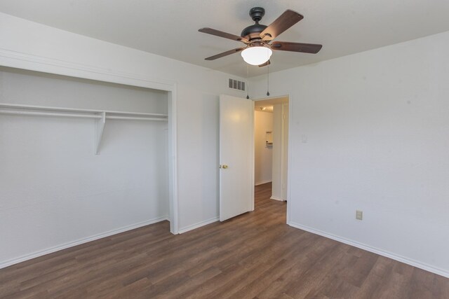 unfurnished bedroom with ceiling fan, dark hardwood / wood-style flooring, and a closet