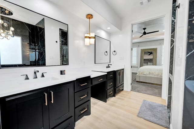 ensuite bathroom with wood finished floors, a sink, visible vents, double vanity, and ensuite bath