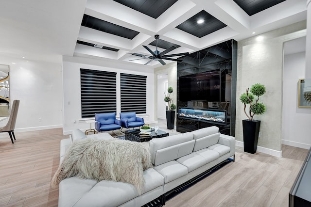 living room featuring light wood finished floors, coffered ceiling, a ceiling fan, and a high end fireplace