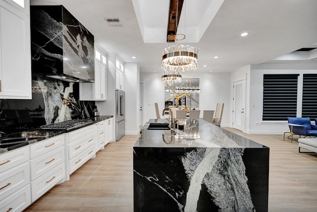 kitchen featuring recessed lighting, a sink, light wood-style floors, appliances with stainless steel finishes, and a tray ceiling