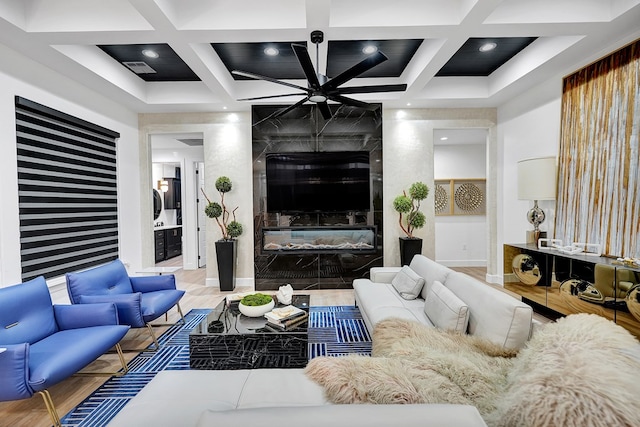 living area featuring visible vents, baseboards, coffered ceiling, beamed ceiling, and a high end fireplace